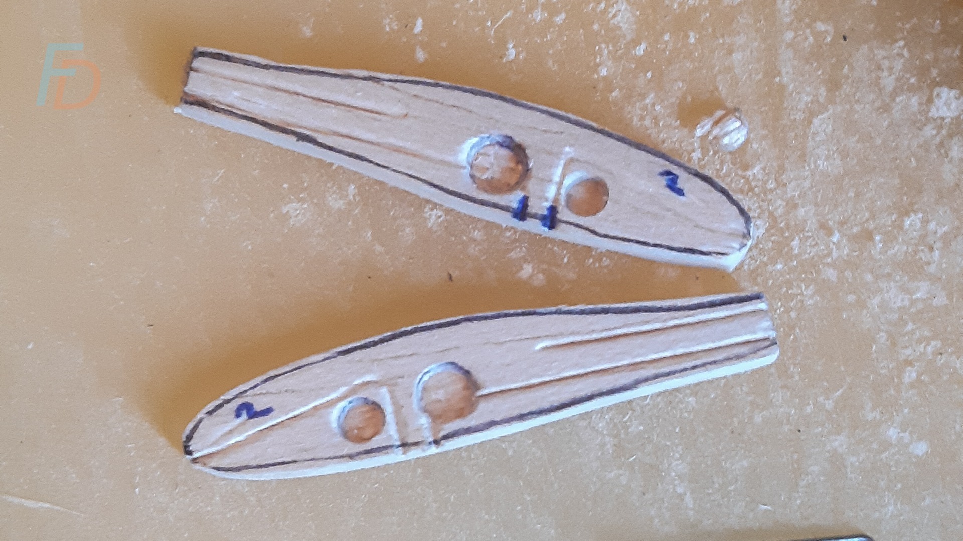 Cavities punched into the two halves of a flat sided balsa minnow